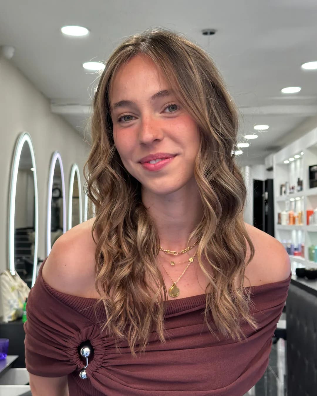Coupe femme chez Jean Bonan : une cliente souriante aux cheveux longs travaillés dans un salon