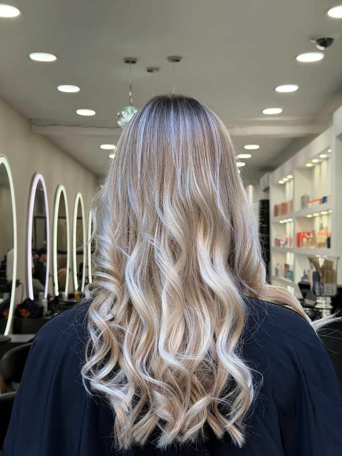 Longs cheveux blonds ondulés avec balayage, couleur entretenue et lumineuse